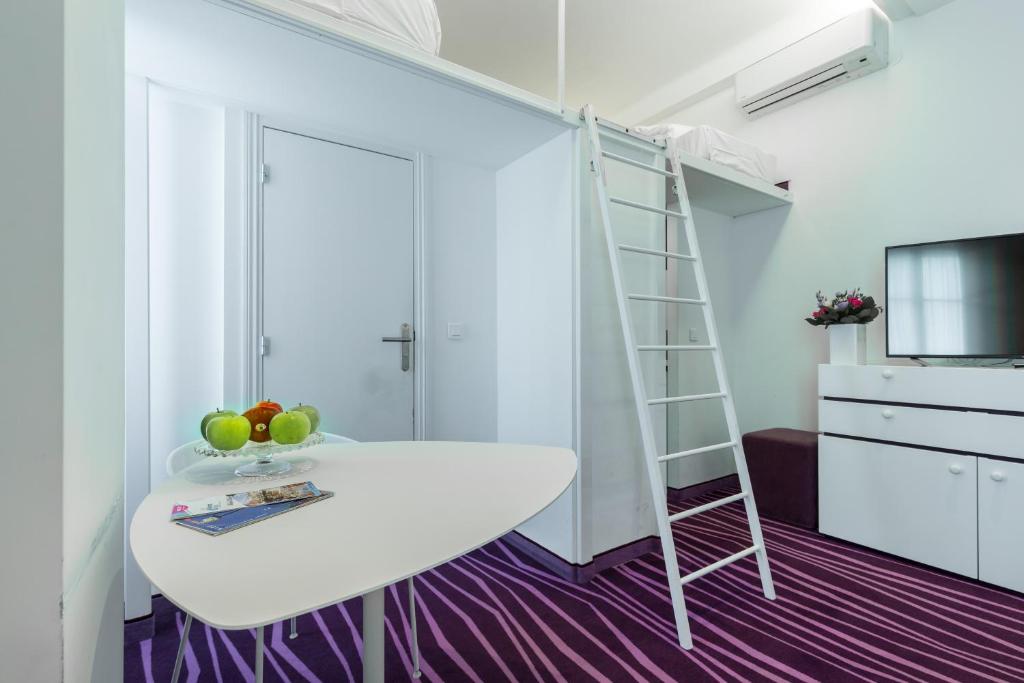 a room with a bed and a desk and a ladder at Nice Appart in Nice