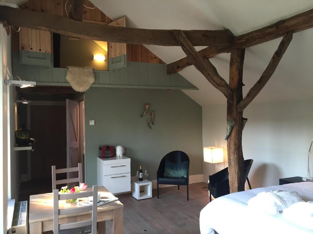 Zimmer mit einem Bett und einem Tisch sowie einem Zimmer mit einem Baum in der Unterkunft Onder de Noot in Baarlo