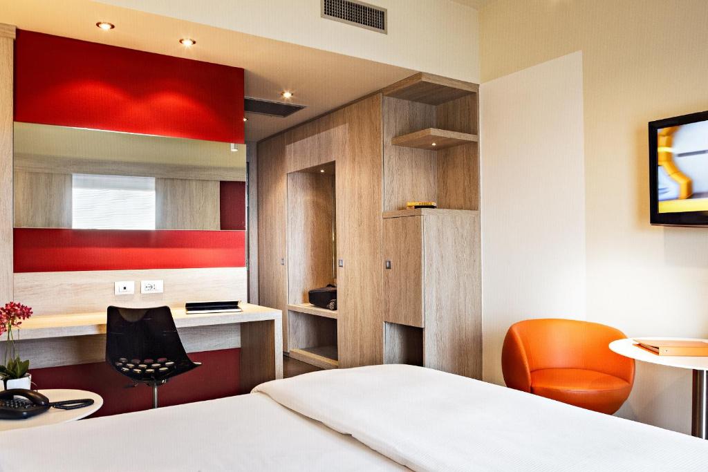 a bedroom with a bed and a desk and a chair at Jazz Hotel in Olbia