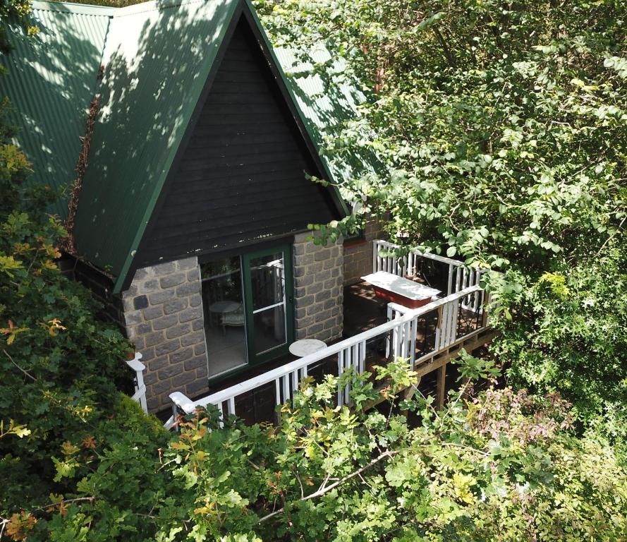 a small house with a balcony in the trees at The Cottage at Mirador Springs Retreat 