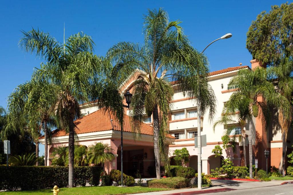 a building with palm trees in front of it at Ramada by Wyndham South El Monte in South El Monte