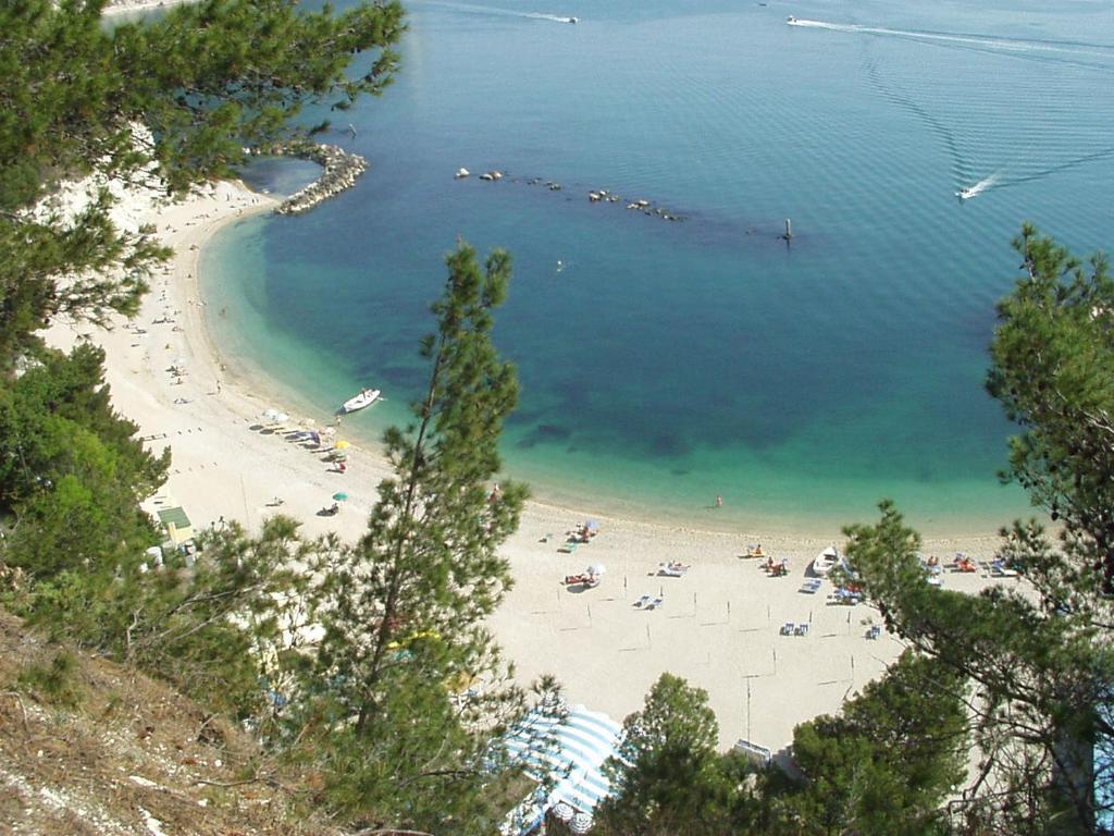 a beach with a bunch of people in the water at Appartamento Mario in Sirolo