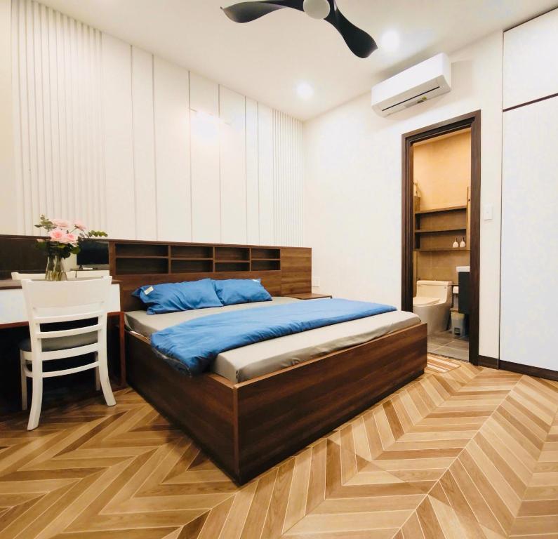 胡志明市Kim's studio的一间卧室，配有一张床、一张书桌和一张桌子