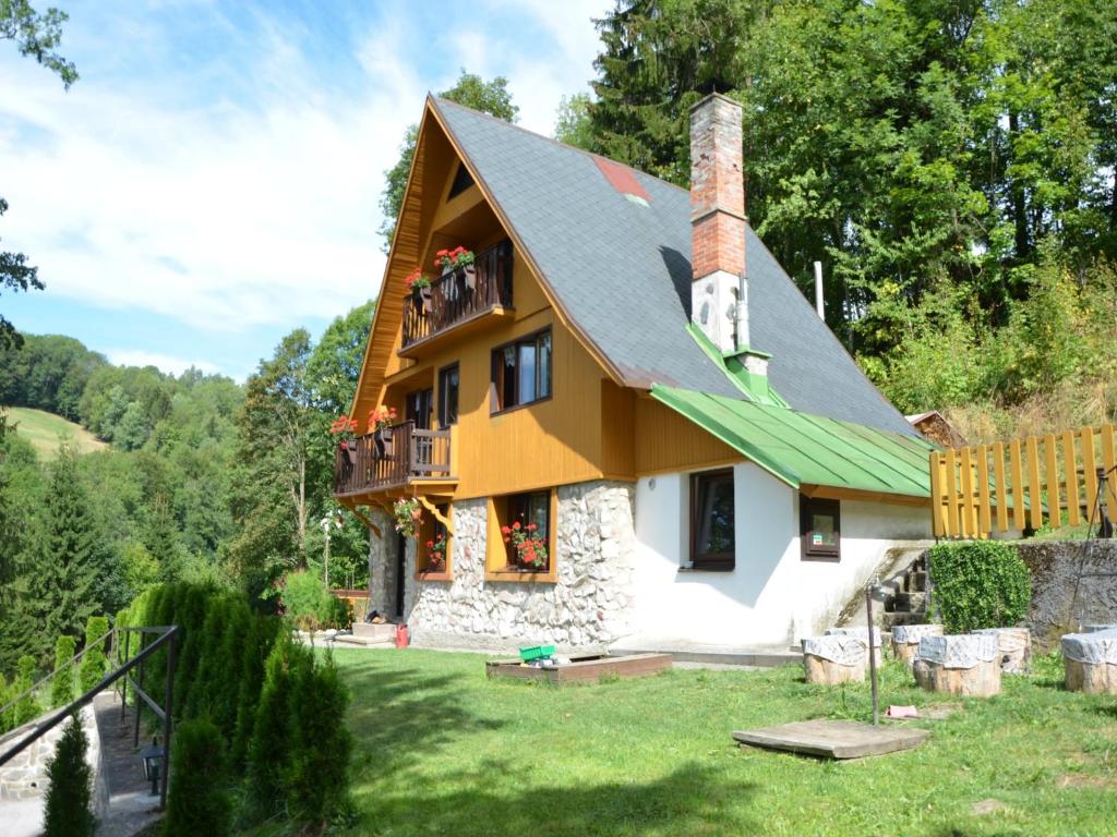 a house with a green roof with people on the balcony at Family Chalet in Giant Mountains in Mrklov