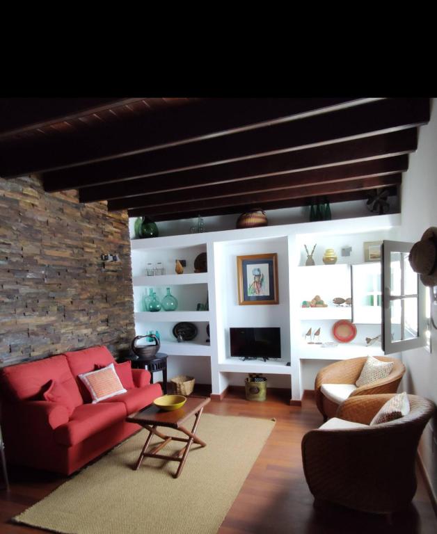 a living room with a red couch and a tv at Casa Vento in La Asomada