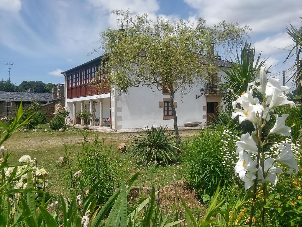 a house with white flowers in the yard at Casa Grande de Anllo in Sistallo