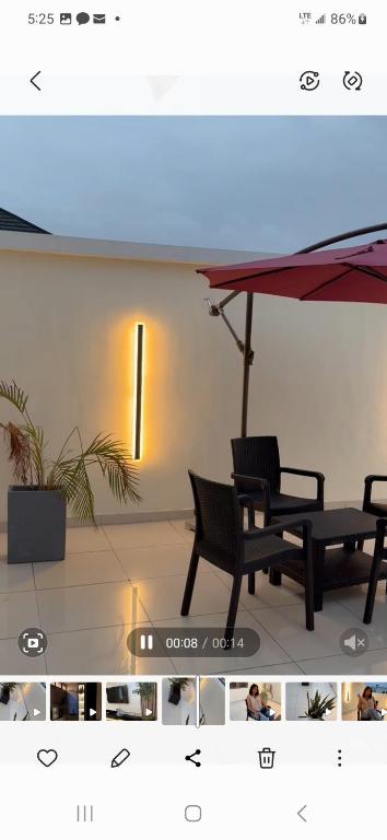 dwa czarne krzesła ustawione pod parasolem w pokoju w obiekcie Eso w mieście Lekki