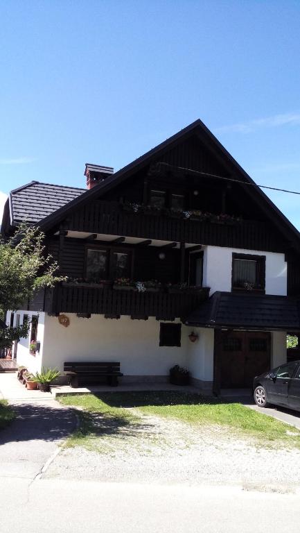 a white house with a black roof at Apartment Cvetek Janez in Bohinj