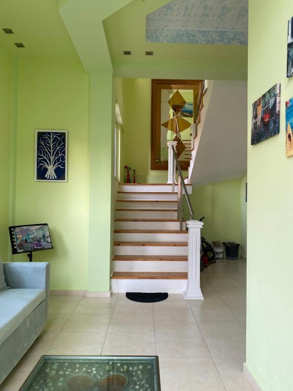a living room with a staircase and a couch at Villa Sopebra in Sarandë