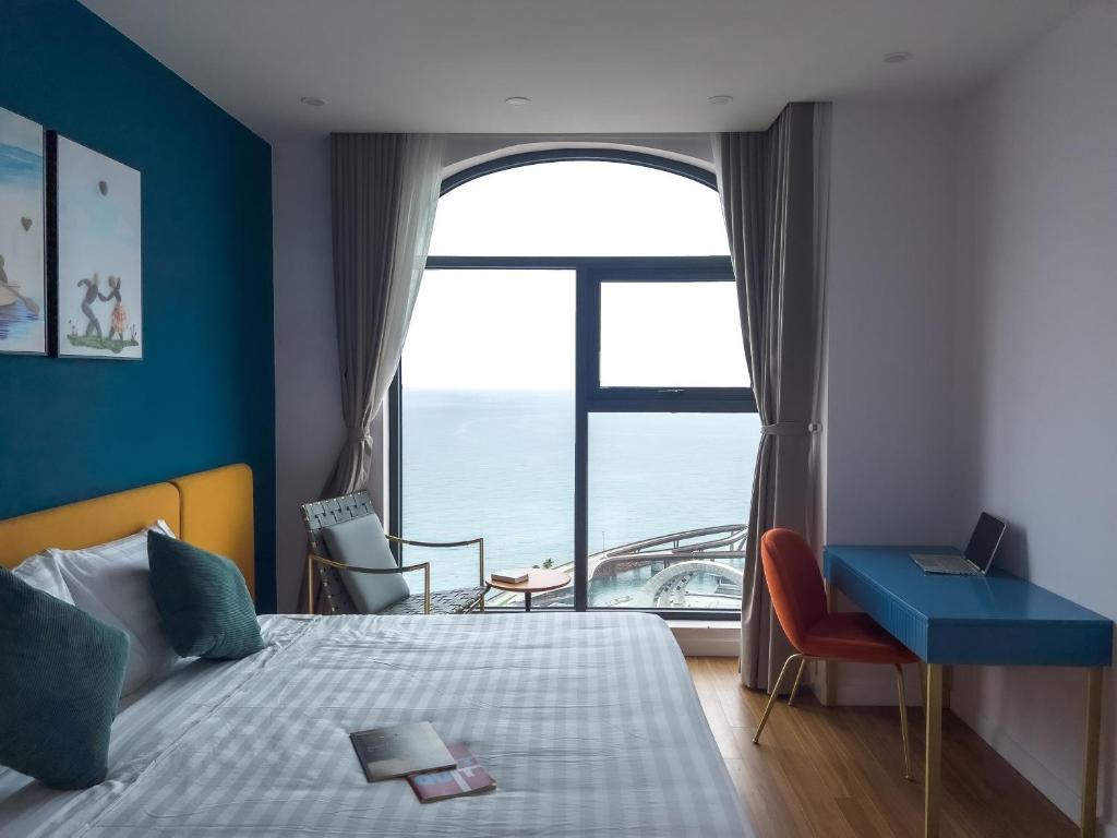 a bedroom with a bed and a large window at Sunset Town Apartments Free Gym & Pool in Phu Quoc
