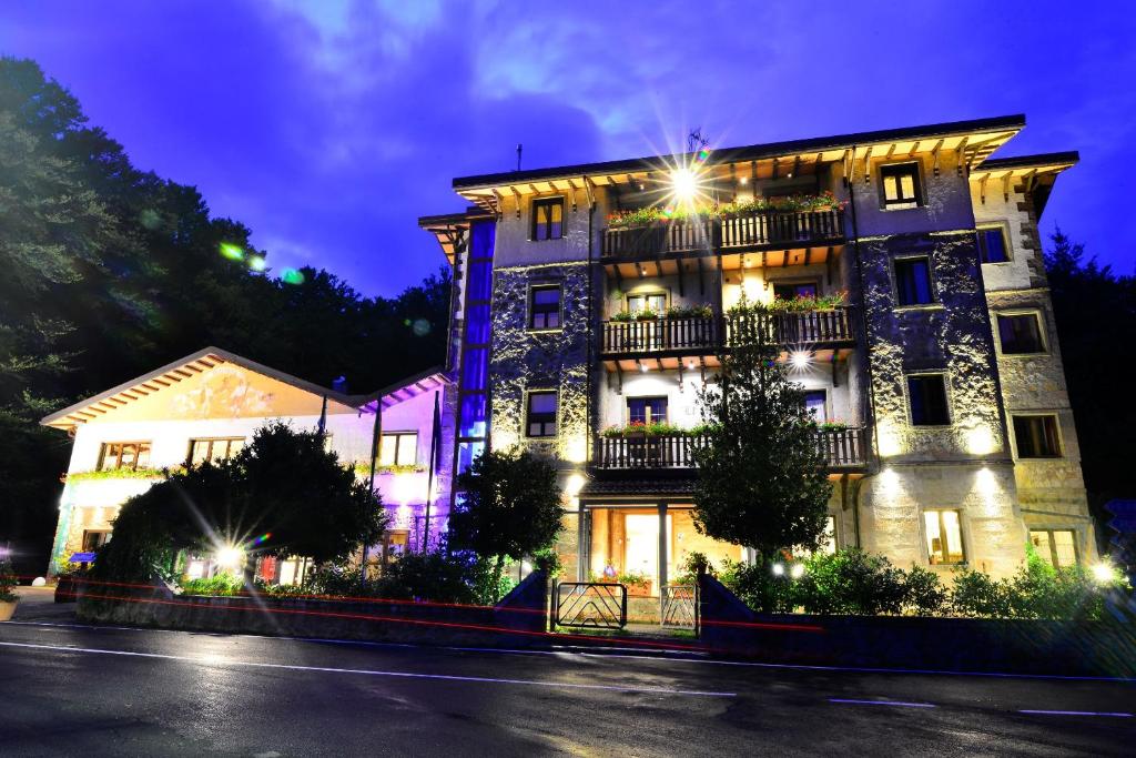 a large building with lights on it at night at Albergo Le Macinaie - Monte Amiata in Castel del Piano