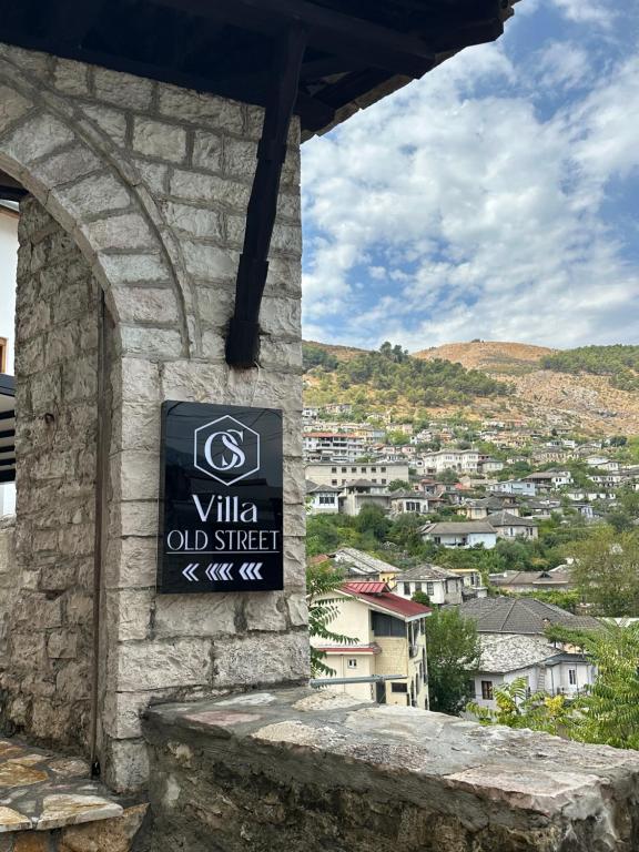 a sign on a building with a view of a city at Old Street Villa in Gjirokastër