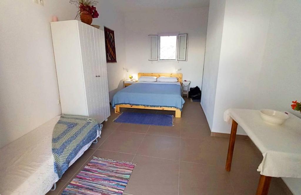 a small bedroom with a bed and a table at Στούντιο 1 in Donoussa