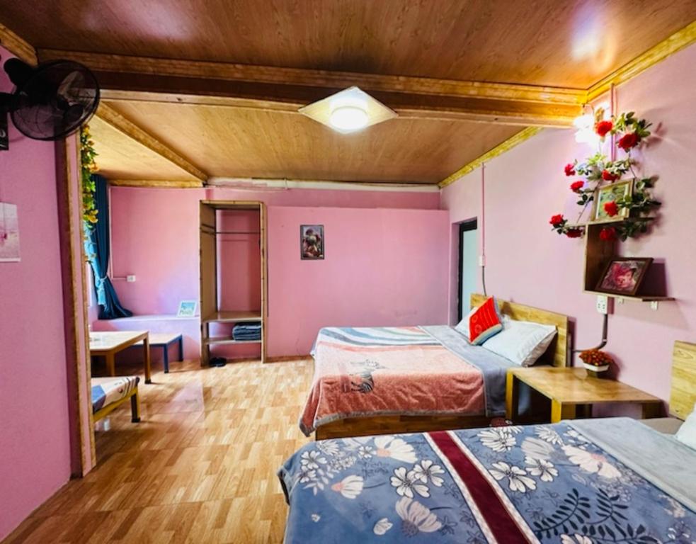 a hotel room with two beds and a table at Terrace House Tả Van in Sa Pa