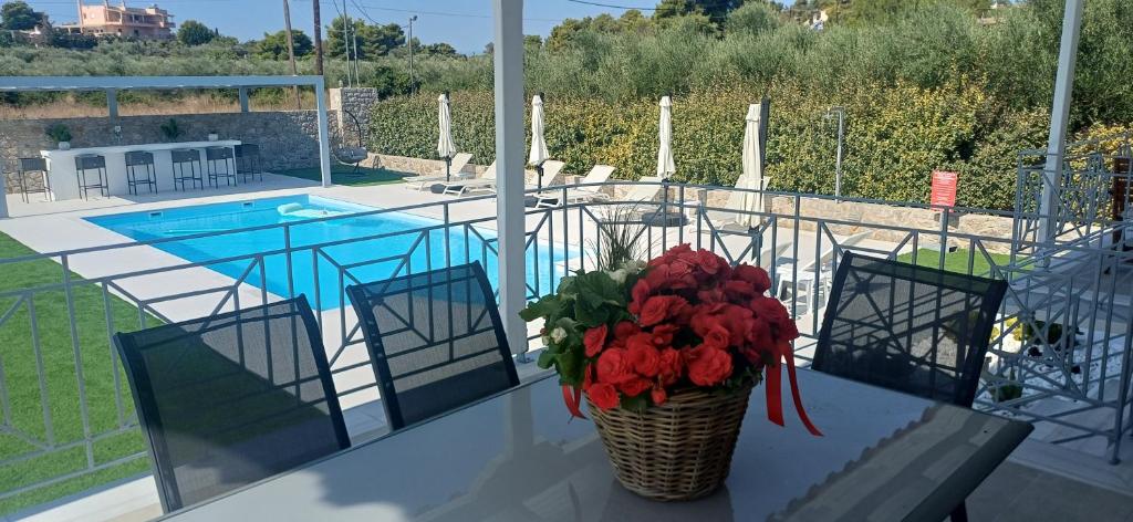 a vase of flowers on a table next to a pool at Guest House Mary in Porto Heli