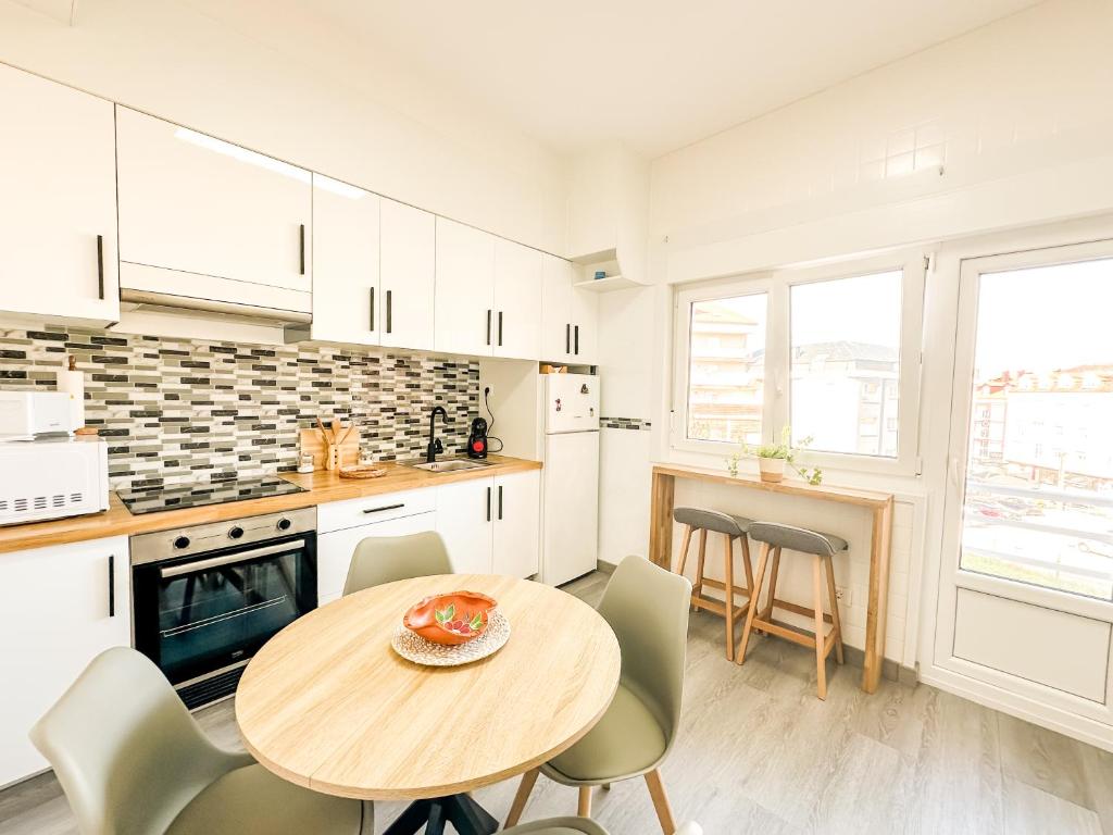 a kitchen with a table and chairs in a kitchen at Apartamento Susurros do Atlántico by ALÔGA in Fisterra