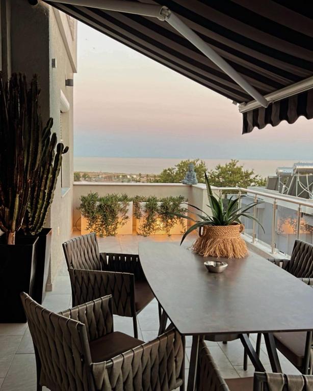 a table and chairs on a balcony with a view at Sea View Residence by MD in Alexandroupoli