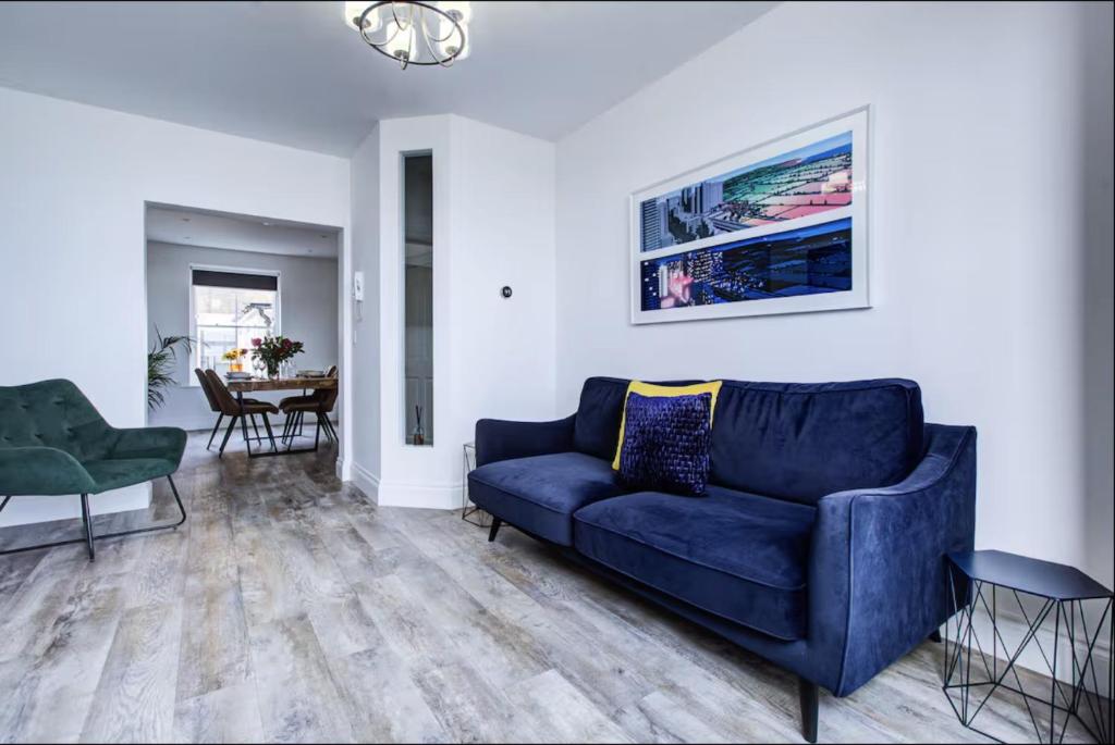 a living room with a blue couch and a table at Luxury 2 Bed Apartment with Stunning Sea View Steps from Old Town and Dreamland in Margate