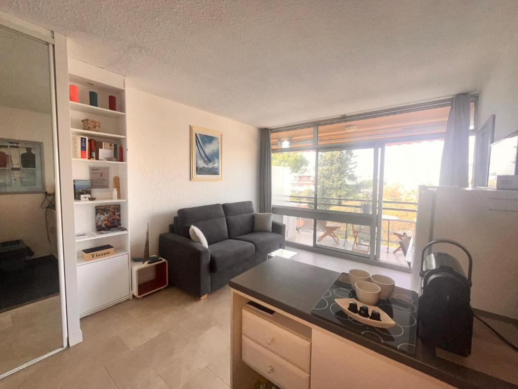 a kitchen and living room with a couch and a table at Heliotel Marine Studio 30m2 très lumineux avec terrasse 17m2 au 3eme étage in Saint-Laurent-du-Var
