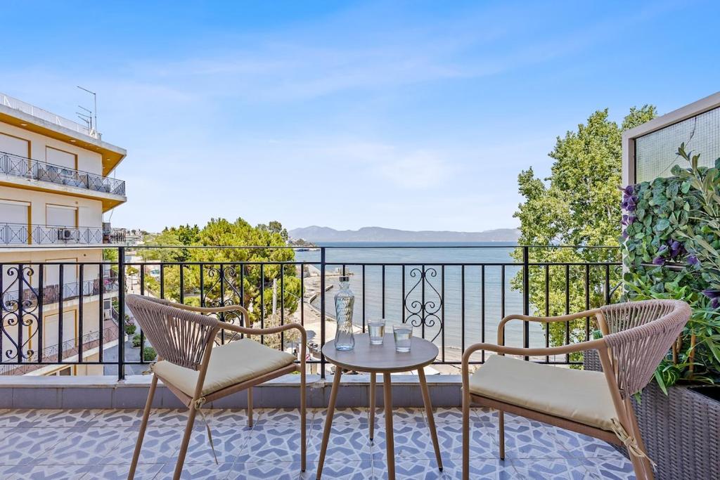 a balcony with chairs and a table with a view of the water at Central Beachfront Apt with a Breathtaking View! in Chalkida