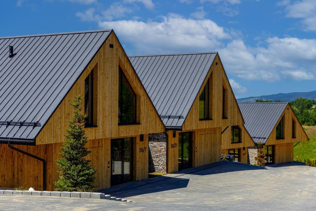 a large wooden barn with a metal roof at Czorsztyn Prestige Ville in Kluszkowce