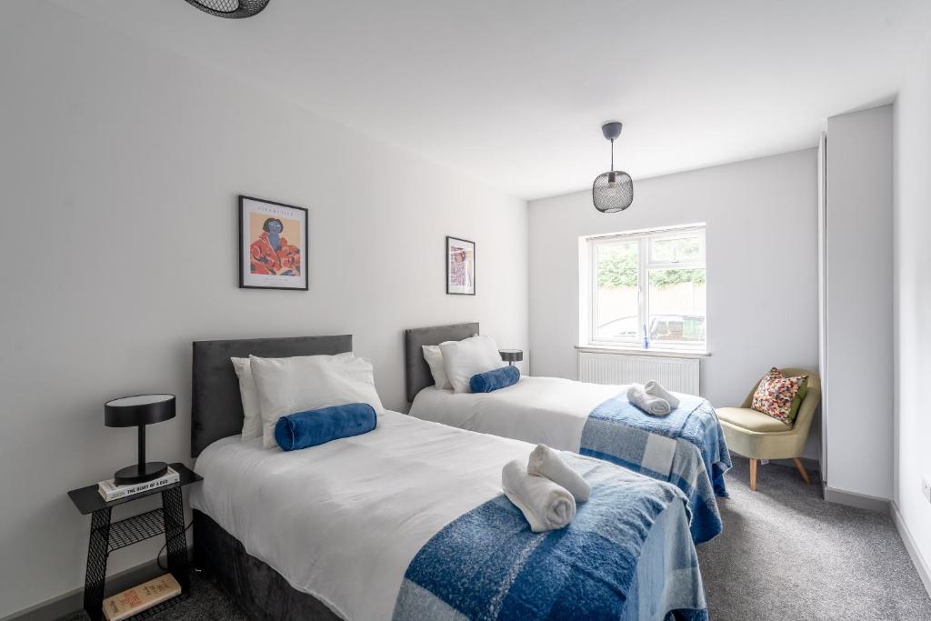 ein Schlafzimmer mit zwei Betten mit Handtüchern darauf in der Unterkunft 4Beds Contractor and Family Haven near Pinewood and Warner Bro studios in Chalfont Saint Peter