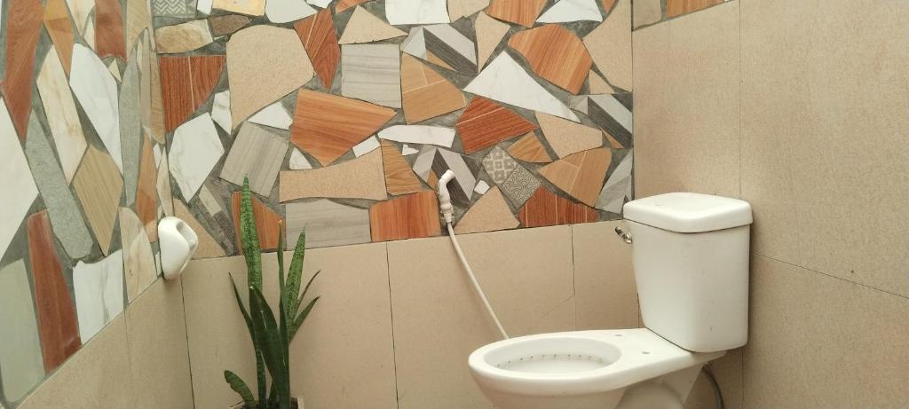 La salle de bains est pourvue de toilettes et d'un mur coloré. dans l'établissement Villa Catalina Leisure resort, à Nabas