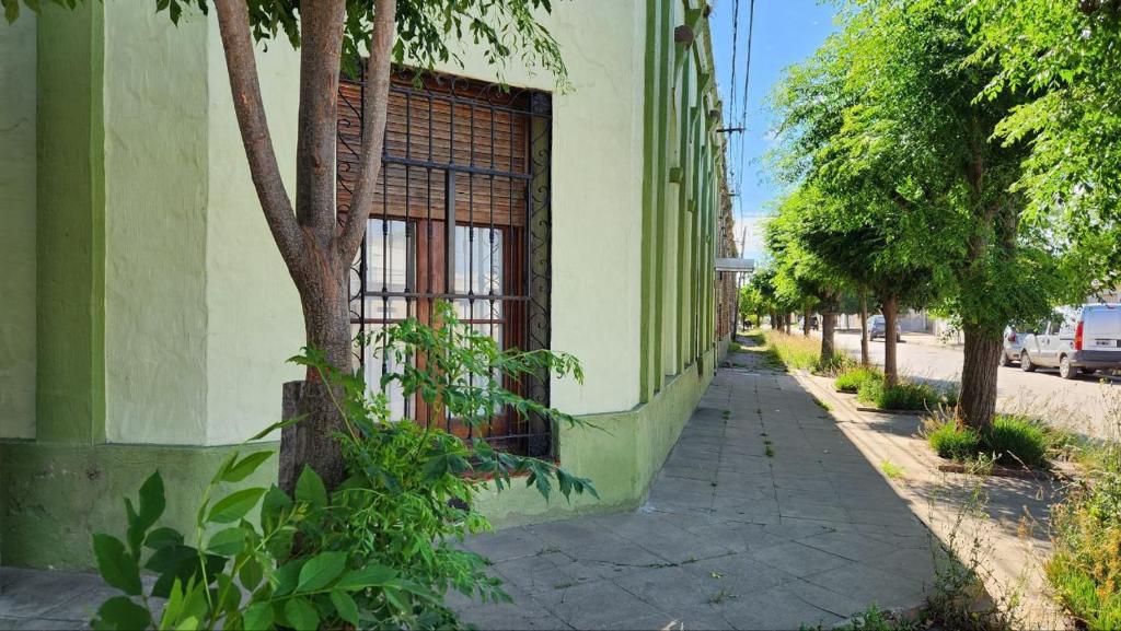 a building with a gate on the side of a street at La casa de la abu in Carmen de Areco