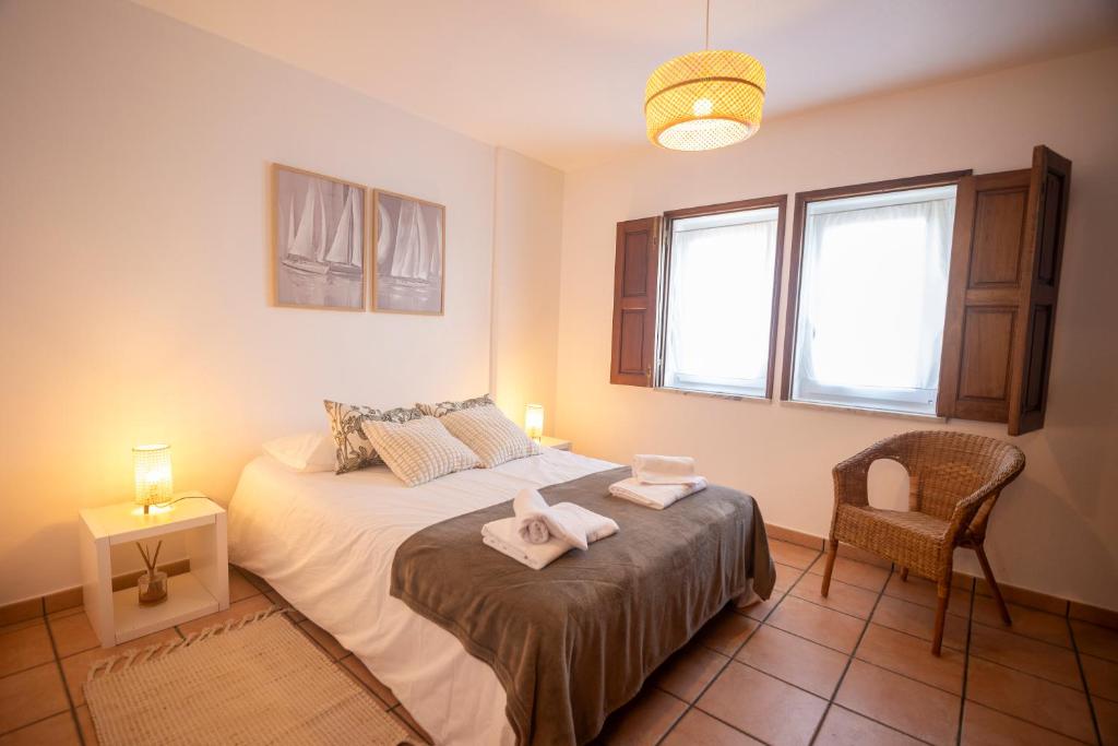 Un dormitorio con una cama y una silla y una ventana. en Baleal Beach Haven, en Ferrel