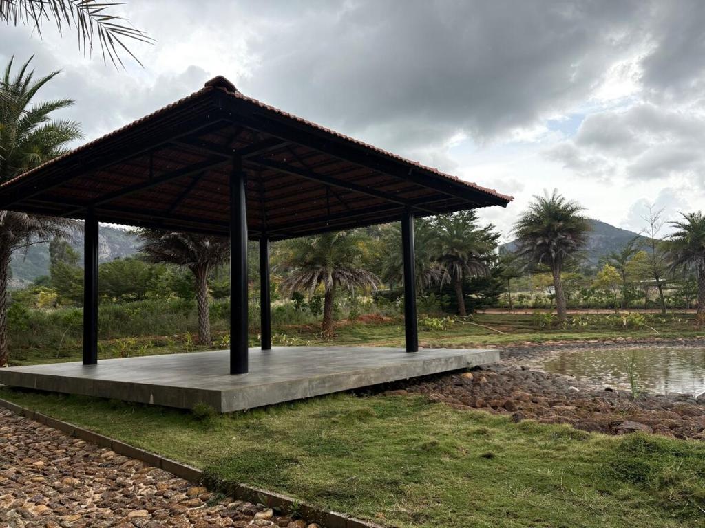 a pavilion in a park next to a body of water at Green Cave Cozy Studio Room in Nandi