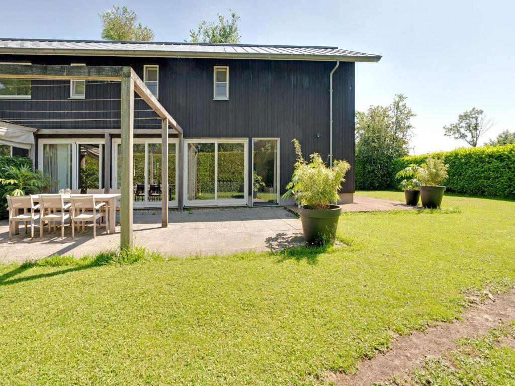 a black house with a patio and a table at Family House in Grou near Water Sports in Grou
