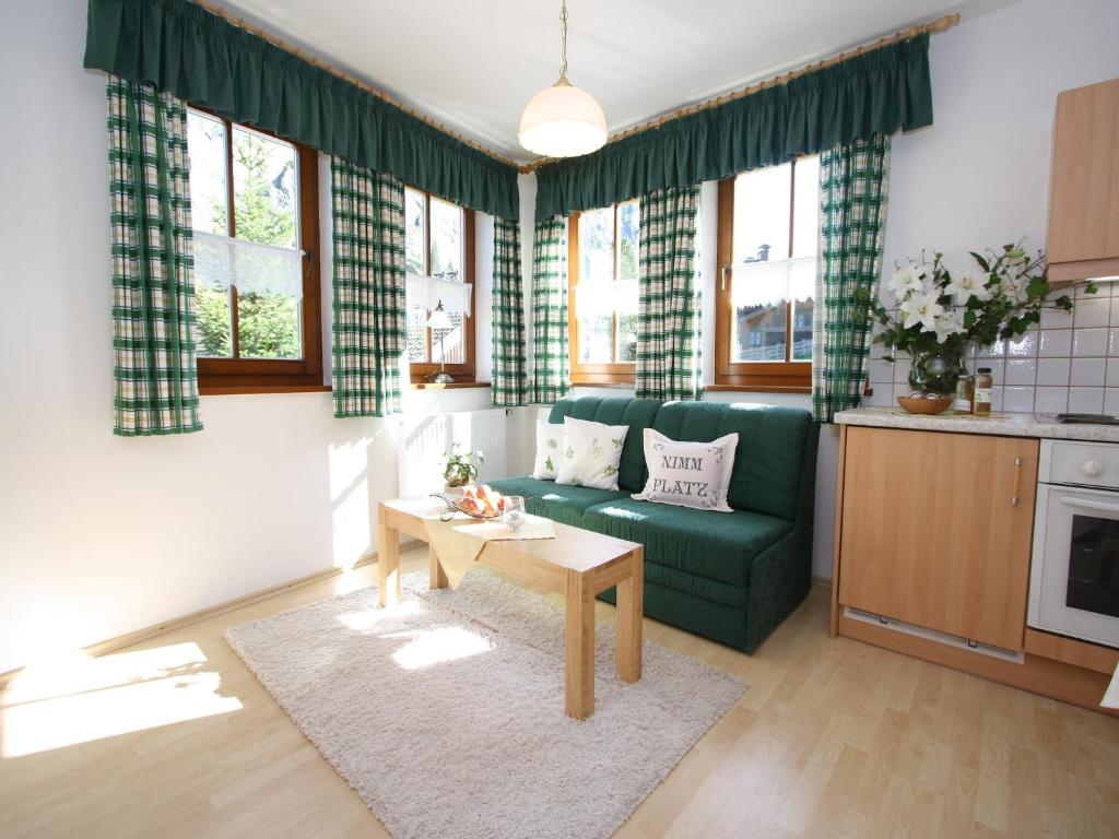 a living room with a green couch and a table at Apartment in Hüttschlag near Ski Bus in Hüttschlag
