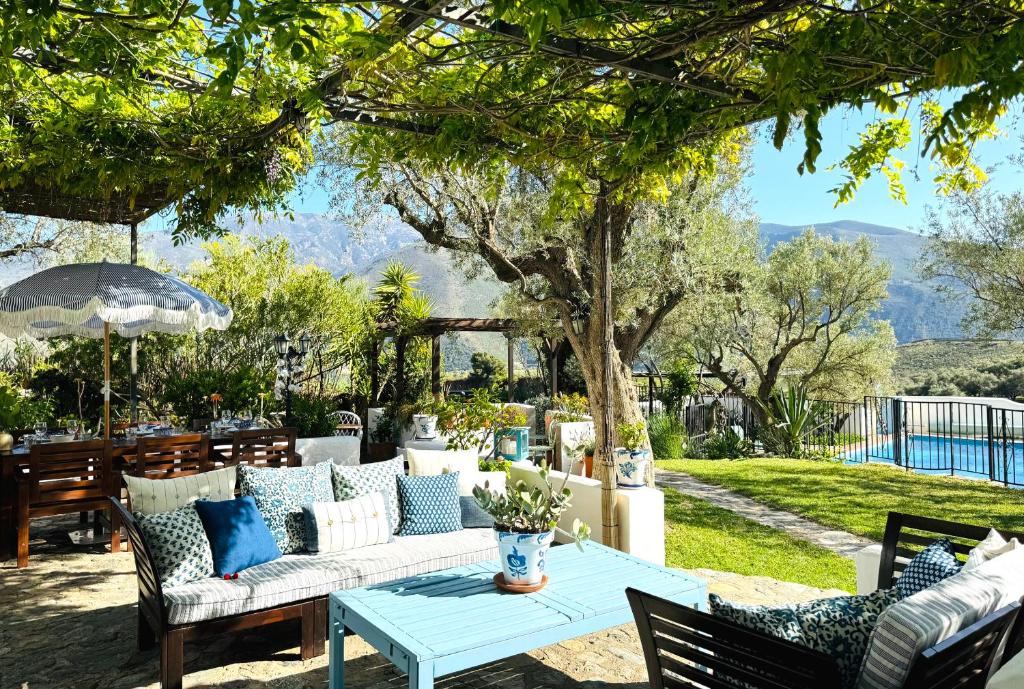 Un patio con sofás blancos y una mesa con en Almond Hill House, en Órgiva