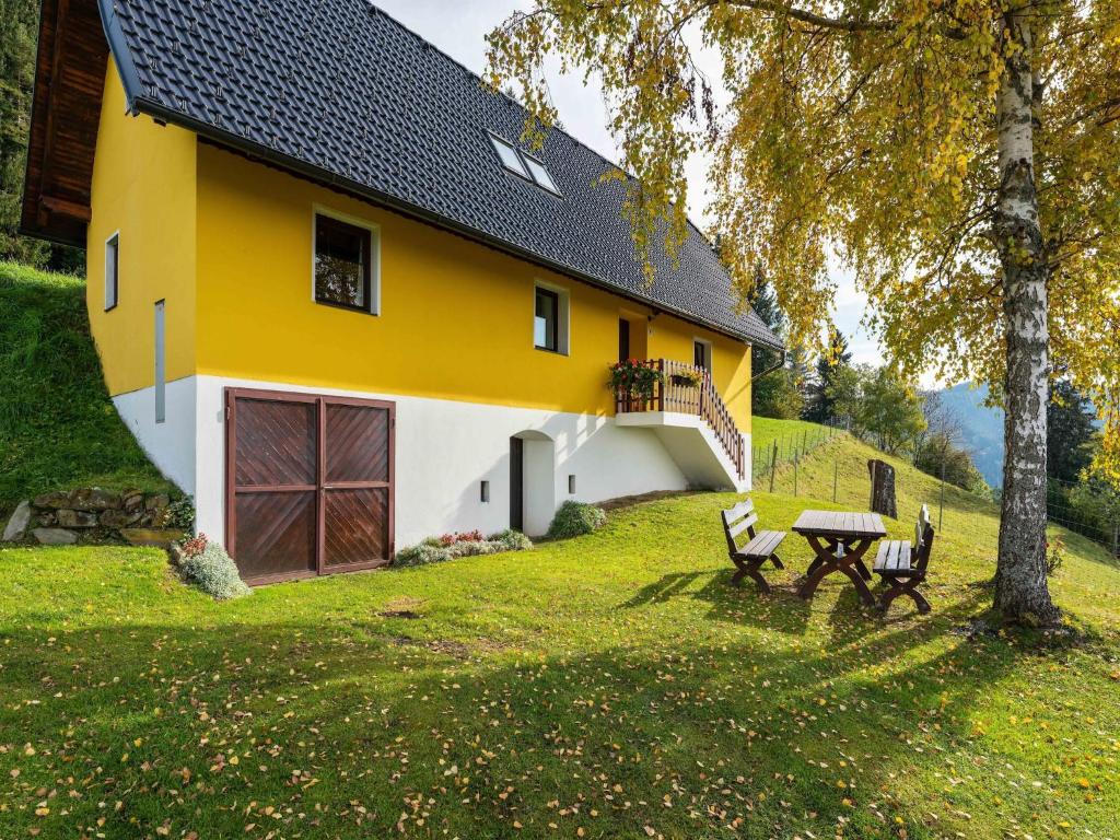 a yellow and white house with a picnic table in front of it at Chalet in Eberstein nahe Saualpe Skigebiet in Eberstein
