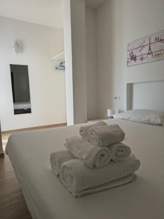 a white bedroom with towels on a bed at Casa indipendente Roque Vista al mar con parking gratuito in Vallecrosia