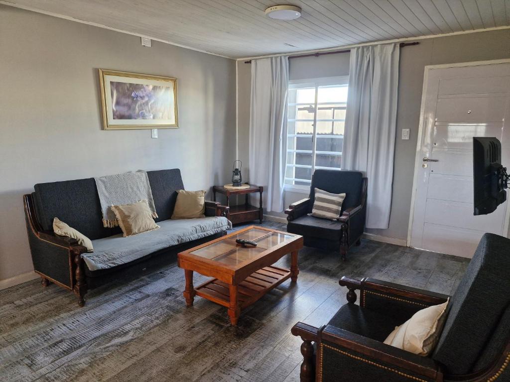 a living room with a couch and chairs and a table at Casa de Descanso Azul con Piscina in Azul