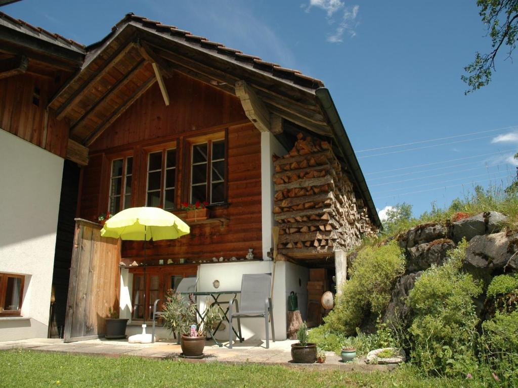 ein Holzhaus mit einem Tisch und einem Sonnenschirm in der Unterkunft Nature Escape in Kander Valley in Kandergrund
