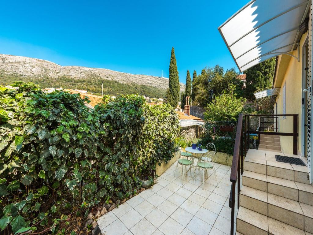 a patio with a hedge and a table and chairs at Dubrovnik Coastal Gem in Dubrovnik