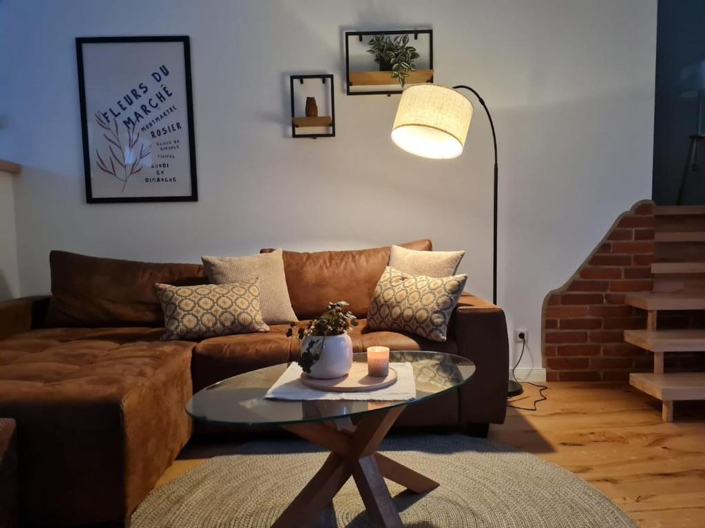 a living room with a brown couch and a table at Ferienwohnung Ida 90 mq in Gernrode - Harz