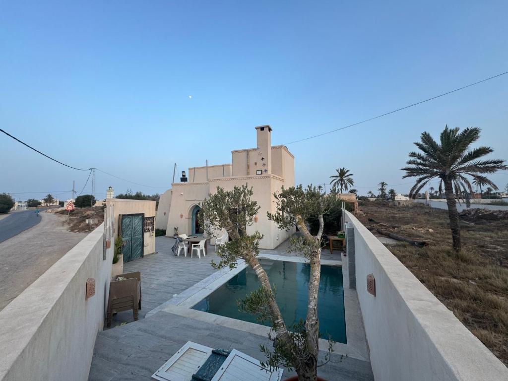 a villa with a swimming pool in front of a house at Traditional home in Temlale