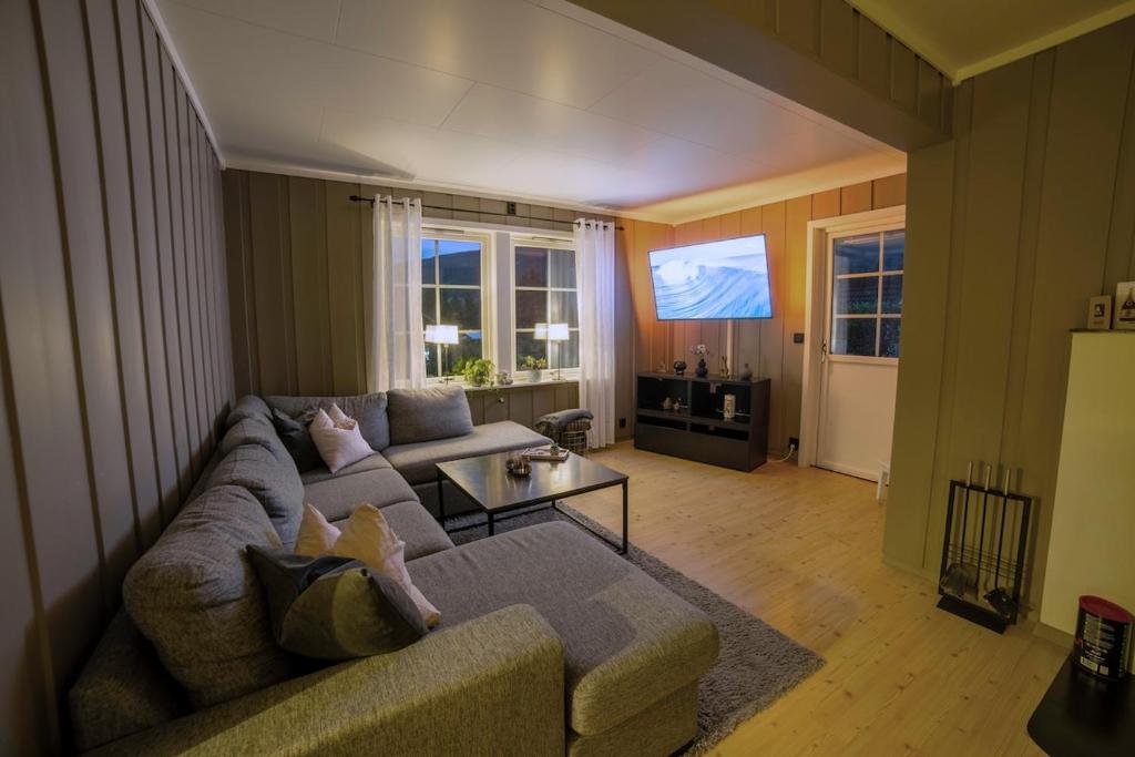 una sala de estar con un sofá y una mesa en Cozy house with free parking on the premises, en Ringebu