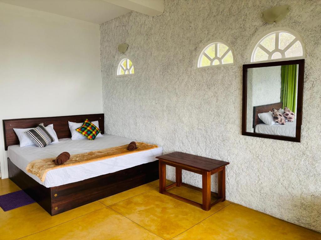 a bedroom with a bed with a mirror and a table at AnS Villas and Apartments in Kandy
