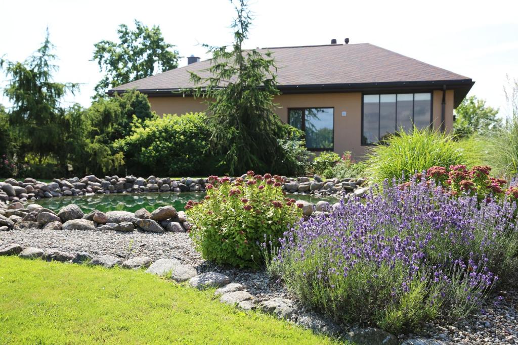 a garden with flowers in front of a house at Lauras Apartment in Bauska
