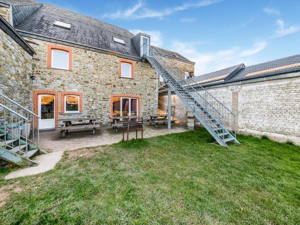 a brick house with a staircase in the yard at Rustic Estate with Sauna in Ambly
