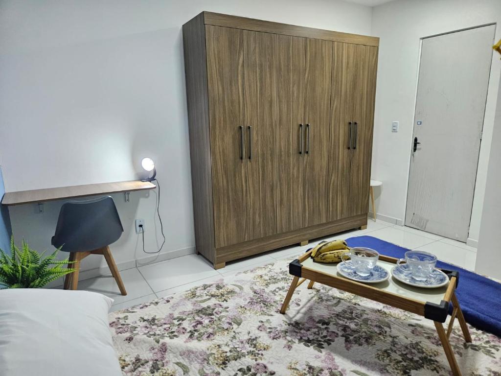 a living room with a cabinet and a coffee table at Casa aconchegante em Parnaíba in Parnaíba