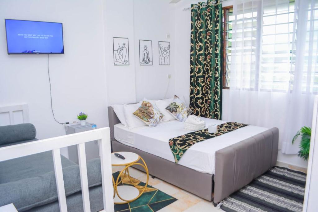 a small bedroom with a bed and a window at The Marve in Mombasa