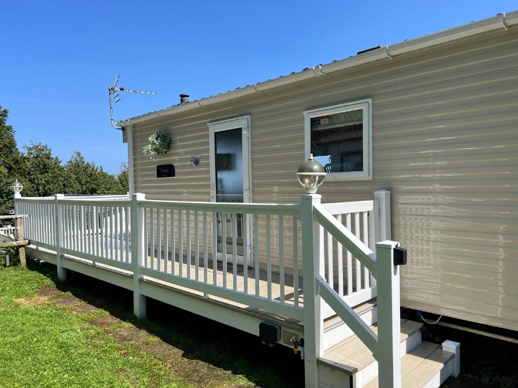 a mobile home with a porch and a white railing at Kieras View At Bideford Bay in Bideford