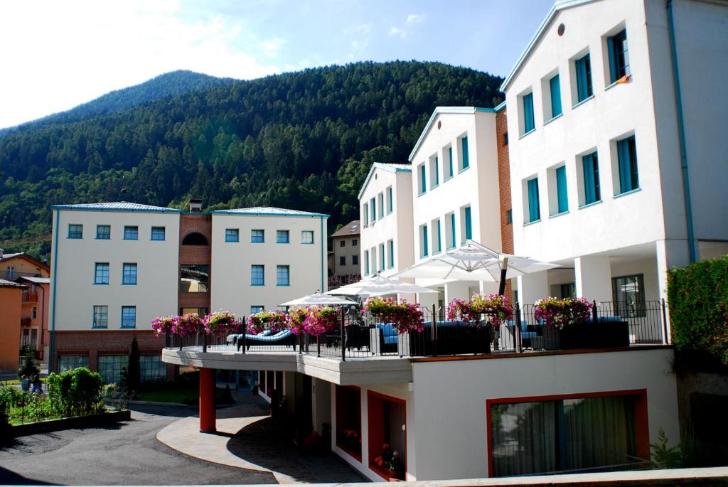 un groupe de bâtiments avec une montagne en arrière-plan dans l'établissement Hotel Sole, à Malè