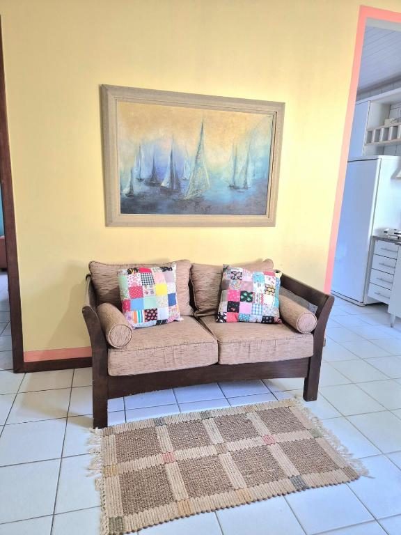 a couch with pillows sitting in a living room at Hospede-se bem em Salinas in Salinópolis