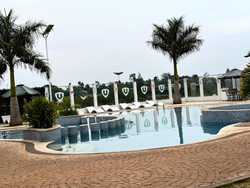 ナイロビにあるRestful Escape- 2br with Pool TatuCityのリゾート内のヤシの木がある大型スイミングプール